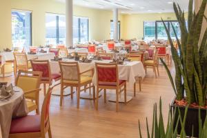 a dining room with tables and chairs and plants at DOMITYS - Le Fil de Soie in Calais