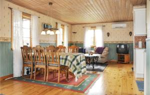 a dining room and living room with a table and chairs at Stunning Home In Gunnarskog With 2 Bedrooms in Gunnarskog