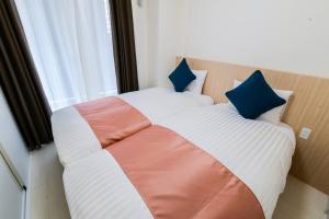 een slaapkamer met een groot bed met 2 kussens bij momo premium 603 in Sapporo
