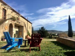 Agriturismo La Valentina Nuova في تالاموني: كرسيين وطاولة أمام المبنى