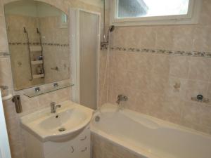 ein Badezimmer mit einem Waschbecken, einer Badewanne, einem Waschbecken und einem Spiegel in der Unterkunft Holiday House Radvanice in Radvanice