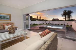 a living room with a white couch and a large window at 269 on Main Holiday Home in Hermanus