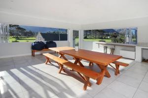 a dining room with a wooden table and benches at 269 on Main Holiday Home in Hermanus