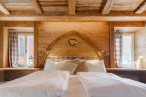 um quarto com uma cama grande e uma parede de madeira em John Luxury Suites em Folgaria
