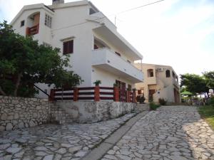 a house on the side of a cobblestone street at Apartments Paro in Pag