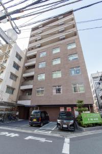two cars parked in a parking lot in front of a building at SHINJUKU Residence BLDG in Tokyo +38 photos
