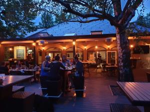 a group of people sitting at tables in a restaurant at Zen Garden Resort, Zánka in Zánka