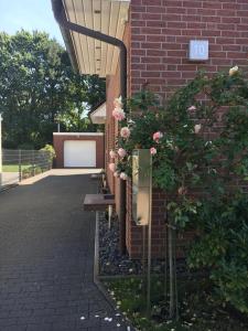 una panchina accanto a un edificio in mattoni con fiori di Modernes Stadthaus 100qm Parkplatz Bad&Dusche Küche ad Hannover