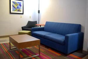 a living room with a blue couch and a table at Holiday Inn Express Hotel & Suites Batesville, an IHG Hotel in Batesville