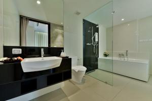 a bathroom with a tub, toilet, sink and mirror at Civic Horizon Hotel & Residence in Bangkok