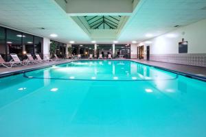 duży basen z niebieską wodą w budynku w obiekcie Holiday Inn Express Big Rapids, an IHG Hotel w mieście Big Rapids