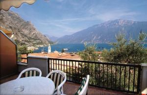 balcone con tavolo, sedie e vista sull'acqua di Residence La Madonnina a Limone sul Garda