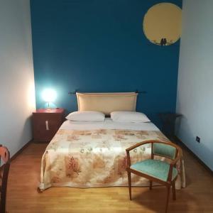 a blue bedroom with a bed and a chair at Le Vallonee B&B in Aradeo