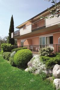 a house with bushes and flowers in front of it at Residence La Madonnina in Limone sul Garda