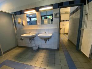 a bathroom with two sinks and a toilet at AZUR Camping Regensburg in Regensburg