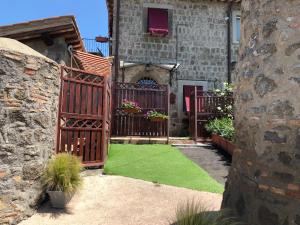 um jardim com um portão de madeira e relva em Agriturismo Specchio Del Lago em Montefiascone