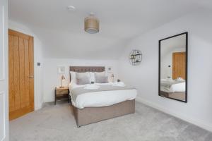 a bedroom with a large bed and a mirror at Dollar Apartments-41 Bridge Street in Dollar
