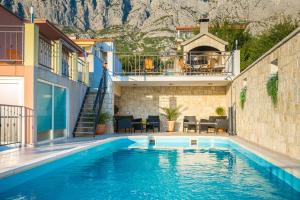- une piscine dans une maison avec une montagne en arrière-plan dans l'établissement Apartments Maša, à Makarska