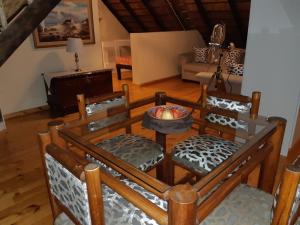 a living room with a table and chairs and a couch at Little Tree Loft in Uitenhage