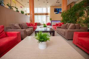 a living room with red couches and plants at Lacoba Hotel in Athens