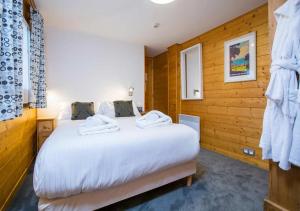 Un pat sau paturi într-o cameră la Simply Morzine - Apartment des Montagnes