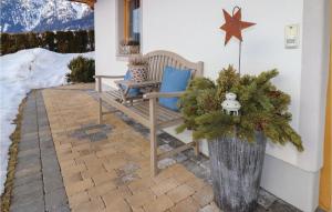 Stunning Apartment In Alpbach With Kitchen في ألباخ: مزهرية مع شجرة عيد الميلاد وجلسة على الفناء