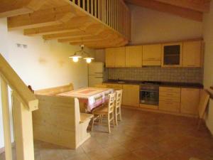 - une cuisine avec une table et des chaises dans la chambre dans l'établissement Agritur Maso Bornie, à Grauno