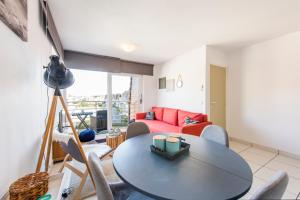 ein Wohnzimmer mit einem Tisch, Stühlen und einem Sofa in der Unterkunft Modern Apartment with Terrace & public Pool in Bredene