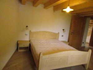 a bedroom with a wooden bed and a night stand at Agritur Maso Bornie in Grauno
