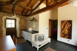 a kitchen with a tv on a white cabinet at A Parada Das Bestas in Pidre