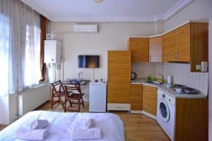 una camera da letto con un letto e una cucina con un tavolo di Sunshine Taksim Suite a Istanbul