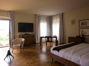 a bedroom with a bed and a desk and a television at Relaisfranciacorta in Corte Franca