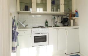 a kitchen with white cabinets and a white stove top oven at Lovely Home In Trosa With Wifi in Trosa