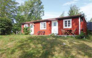 una casa roja y blanca en un campo de hierba en Lovely Home In Trosa With Wifi, en Trosa