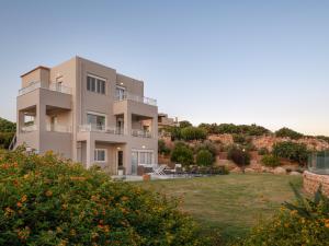 a large house with a yard in front of it at Anemolia Seaview Villa, with private Pool & Garden, By ThinkVilla in Gerani