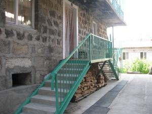 una escalera verde en el lateral de un edificio en Ani Guest House, en Tsaghkadzor