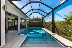 an indoor swimming pool with a glass roof at BEACH 5 MIN. WALK-LUXURIOUS MODERN POOL HOME in Marco Island