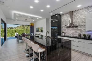 a kitchen with a large island with bar stools at BEACH 5 MIN. WALK-LUXURIOUS MODERN POOL HOME in Marco Island