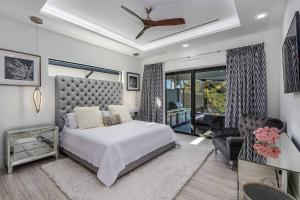 a bedroom with a bed and a couch and a chair at BEACH 5 MIN. WALK-LUXURIOUS MODERN POOL HOME in Marco Island +48 photos
