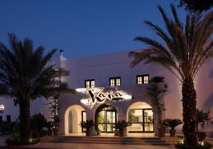 a building with palm trees in front of it at Hotel Karia Princess in Bodrum City