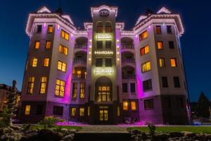 un gran edificio con luces moradas. en Mardan Palace SPA Resort en Bukovel