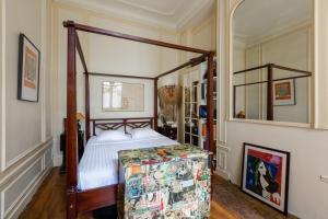 a bedroom with a canopy bed in a room at Veeve - Vintage & Eclectic in the 17th in Paris