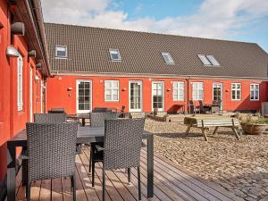 a wooden table and chairs in front of a building at 5 person holiday home in Aakirkeby in Åkirkeby