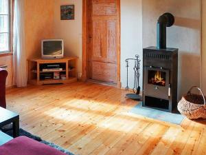 a living room with a woodburning stove and a tv at 4 person holiday home in Sk rblacka in Skärblacka