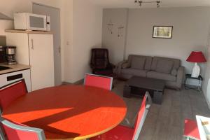 eine Küche und ein Wohnzimmer mit einem Tisch und einem Sofa in der Unterkunft SERRE CHEVALIER 1200 in Briançon