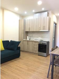 a living room with a couch and a kitchen at Cosy apartment near the sea in Batumi