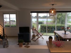 a living room with a table and a large window at Maison vue mer Riantec in Riantec