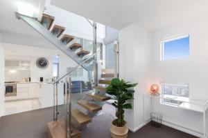 a staircase in a home with white walls at SK1 - 2 level 2 Bedroom Skyline SkyHome in Brisbane