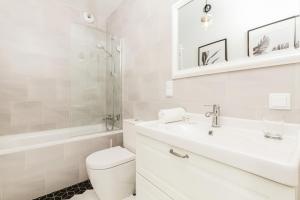 a white bathroom with a sink and a toilet at Apartments Gdańsk Rajska by Renters in Gdańsk