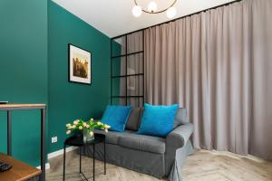 a living room with a gray couch and blue pillows at Apartments Gdańsk Rajska by Renters in Gdańsk